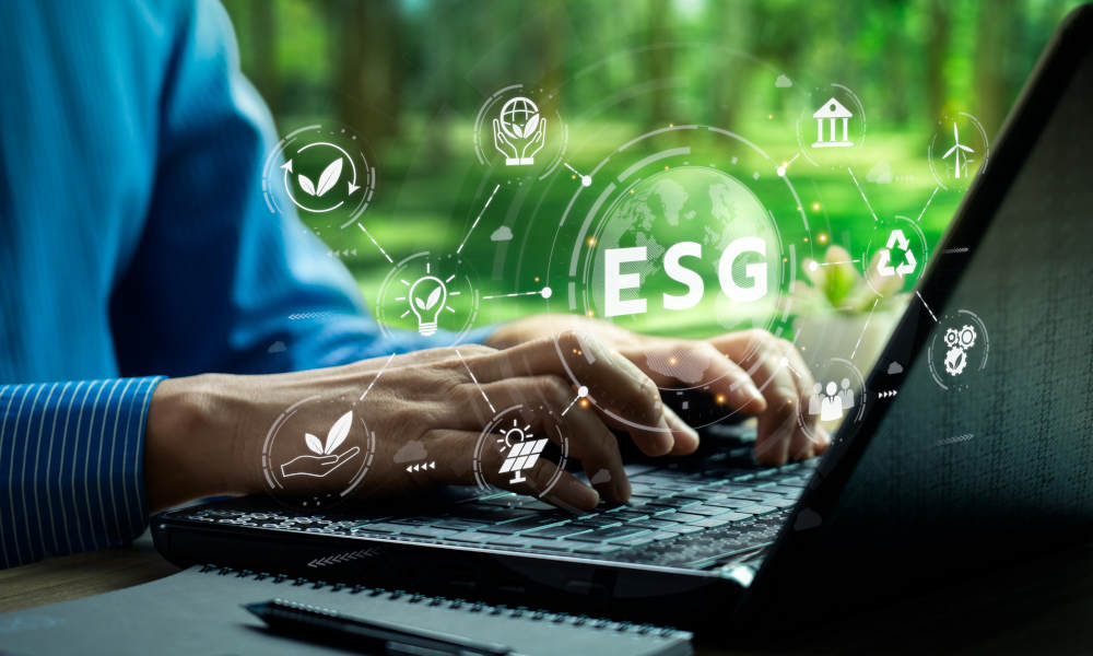 Eine Person tippt auf einem Laptop in einer grünen, natürlichen Umgebung. Über dem Bild liegt eine digitale Montage aus durchsichtigen ESG-Symbolen (Umwelt, Soziales, Governance). 