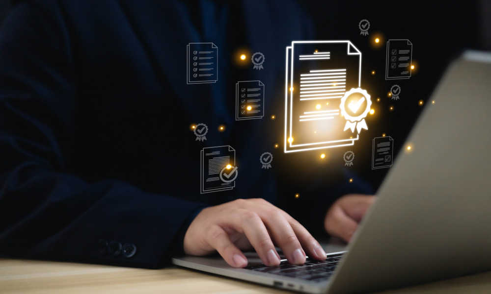 Montage: Eine Person arbeitet am Laptop; vor dem Bildschirm schweben Dokument-Icons; Ein Siegel mit Häkchen zeigt an, dass die Dokumente erfolgreich geprüft wurden.
