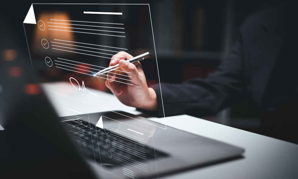 Montage: Ein Laptop steht auf einem Schreibtisch, davor drei Symbole, welche Dokumente darstellen; Eine Person signiert das oberste Dokument mit einem Stift digital.  