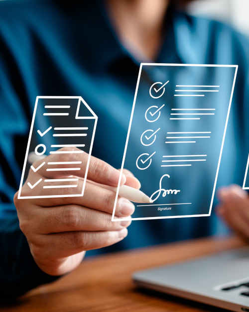 Montage: Person sitting at a laptop, holding a smartphone in the left hand and signing digital documents with a stylus in the right hand; The documents are shown as floating icons in the foreground.